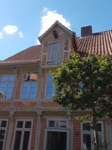 Historische Backsteinfassade des Elbschifffahrtsmuseums in Lauenburg mit Ziegeldach, Giebel und Eingang, teilweise verdeckt von einem Baum.