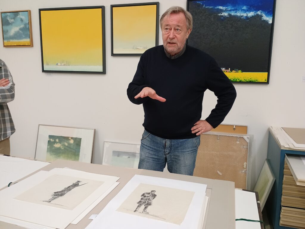 Der Maler Herbert Müller erläutert seine Beziehung zur Geschichte des KZs Engerhafe in seinem Atelier, Foto: Barbara Hartje, 2026